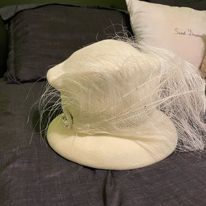 Cream hat embellished with feathers and rhinestones.